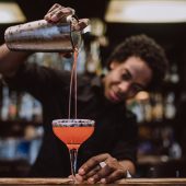 Barman is making cocktail at night club